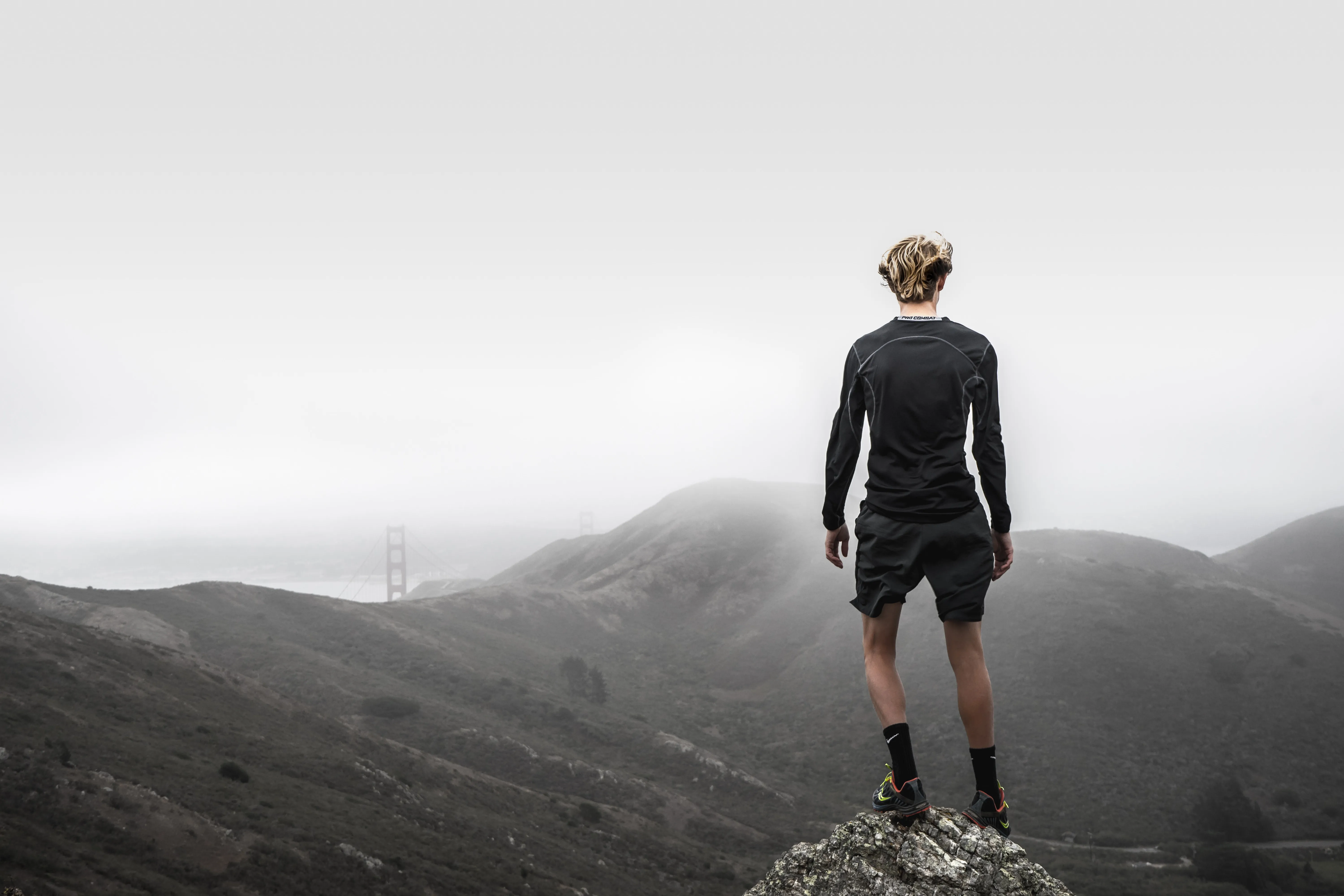 Runner standing atop of mountain