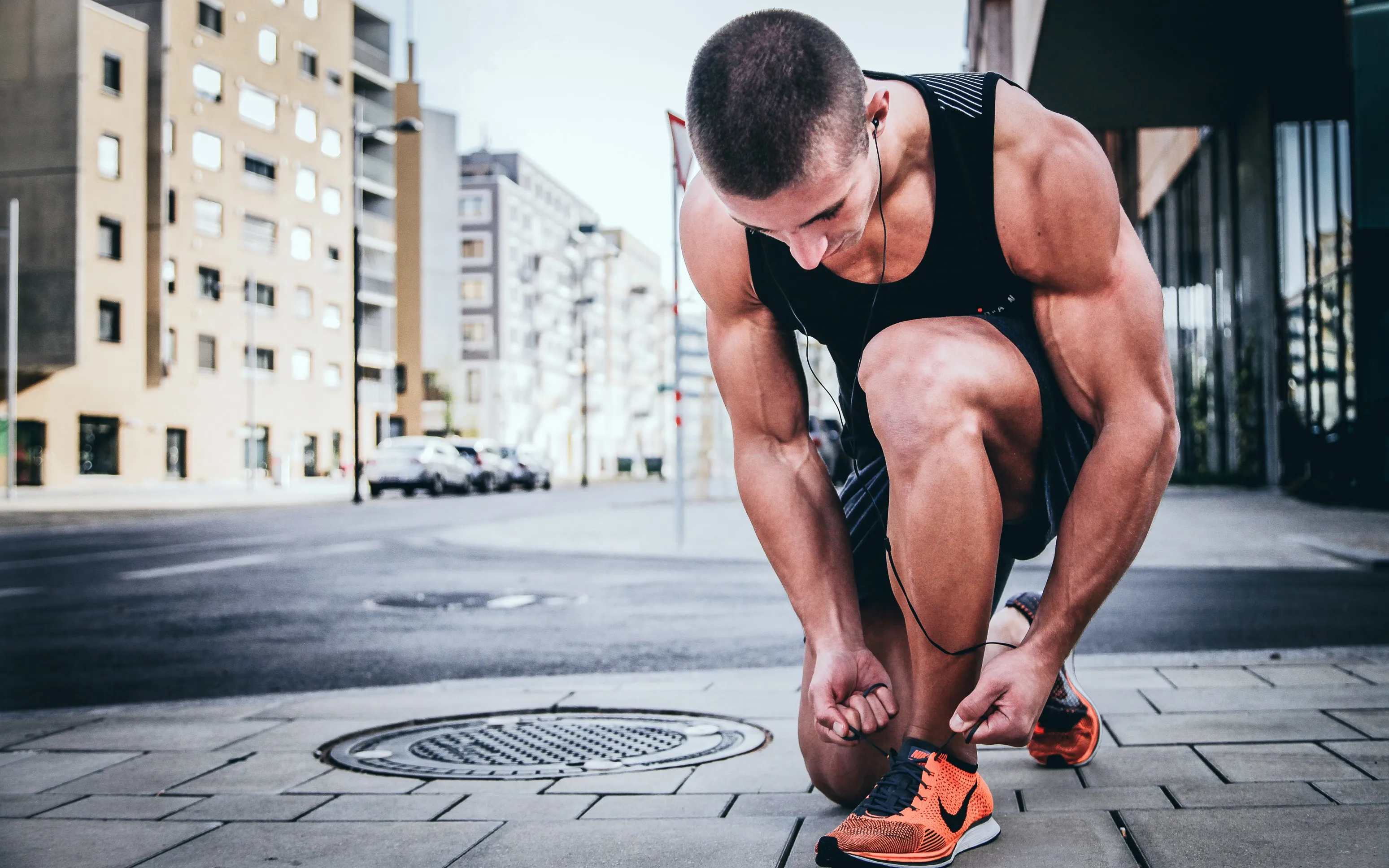 tying shoe on sidewalk